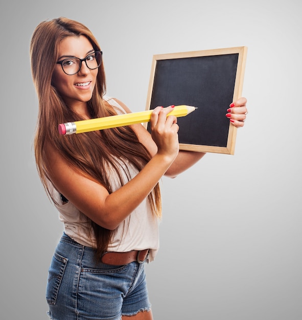 Attraktive Frau, die Tafel und Bleistift