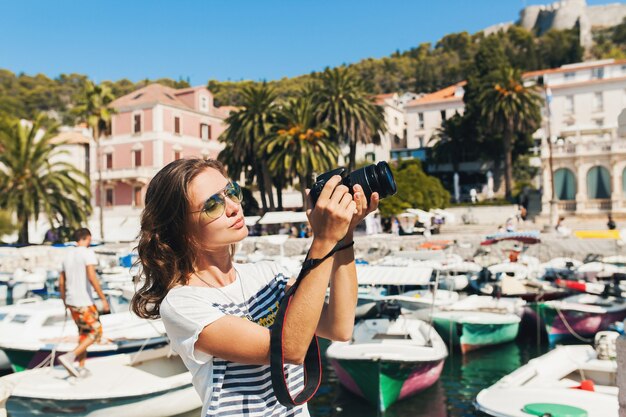 Attraktive Frau im Urlaub in Europa am Meer auf einer Kreuzfahrt, die Fotos vor der Kamera macht