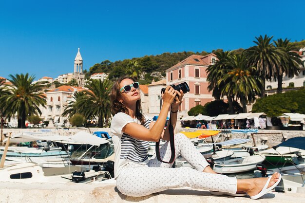 Attraktive Frau im Urlaub in Europa am Meer auf einer Kreuzfahrt, die Fotos vor der Kamera macht