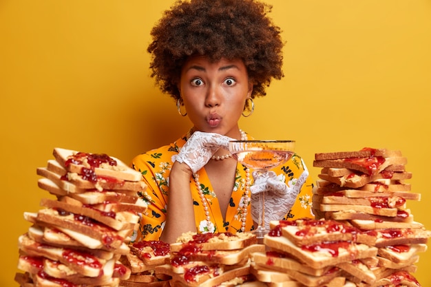 Attraktive Frau mit Afro-Haaren, umgeben von Erdnussbutter-Gelee-Sandwiches