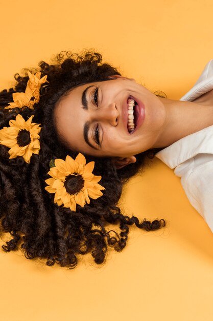 Attraktive fröhliche Frau mit Blumen am Haar