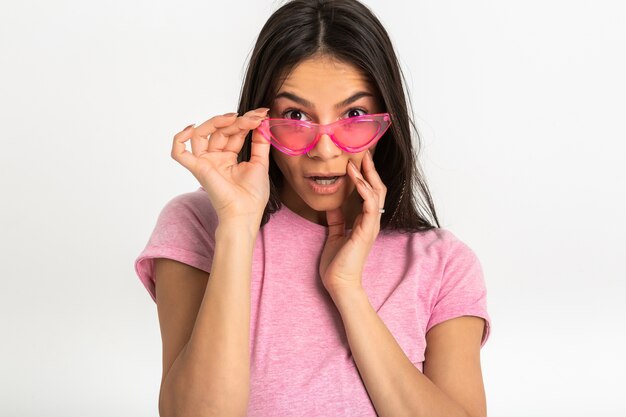 Attraktive glückliche lustige lustige überraschte emotionale Frau im rosa T-Shirt isolierte Arme vorwärts überraschten schockierten Gesichtsausdruck