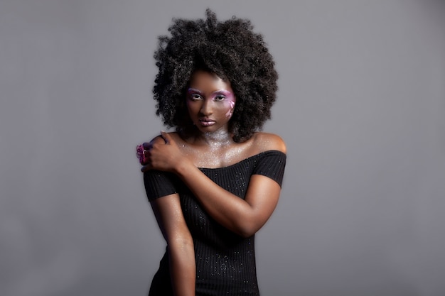 Attraktive junge afroamerikanische frau mit glatter haut, die schönes make-up trägt