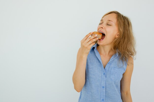 Attraktive junge Frau beißt Kuchen