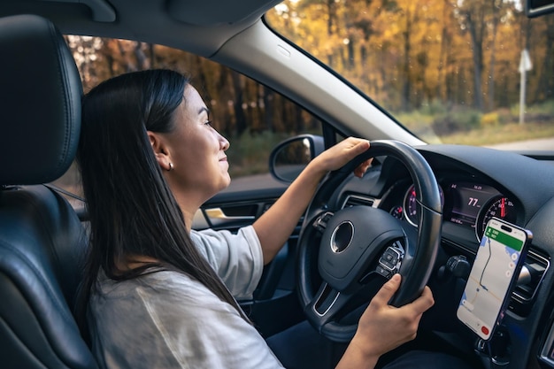 Attraktive junge Frau fährt ein Auto, das von innen aus gesehen wird