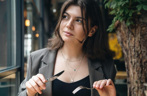 Attraktive junge Frau mit Besteck in einem Restaurant