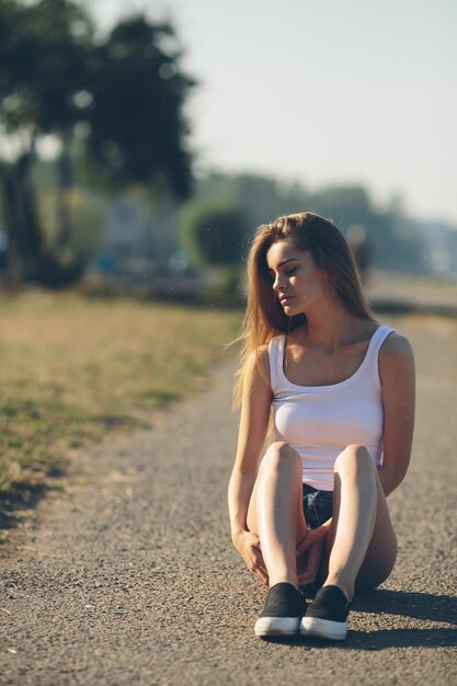 Attraktive junge Frau sitzt auf dem Boden