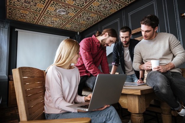 Attraktive Kollegen, die im Büro stehen und arbeiten.