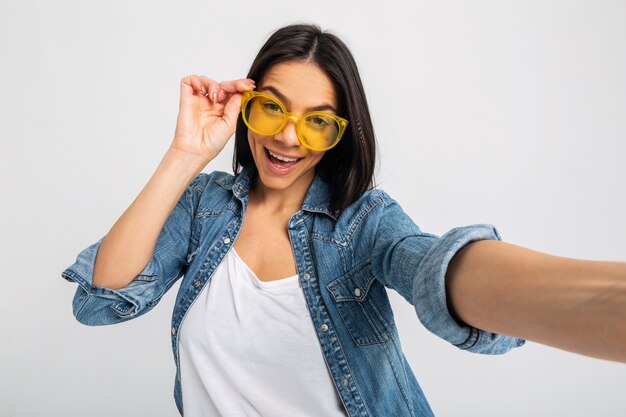 Attraktive lächelnde aufgeregte Frau, die Selfie-Foto mit überraschtem Gesicht lokalisiert auf Weiß macht