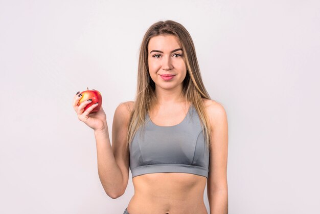 Attraktive positive Frau mit Apfel