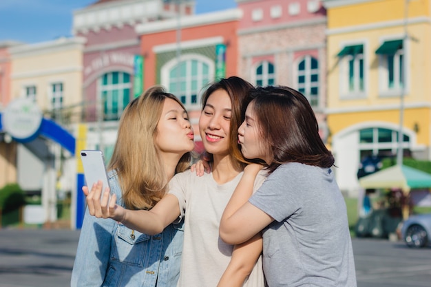 Attraktive schöne asiatische Freundfrauen, die einen Smartphone verwenden. Glücklicher junger asiatischer Teenager