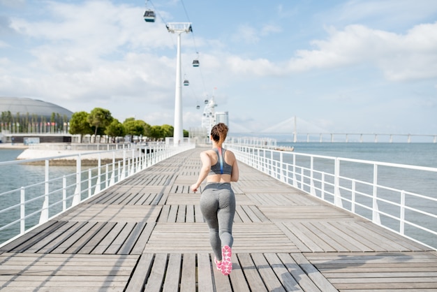 Attraktive sportliche Frau, die auf Brücke läuft