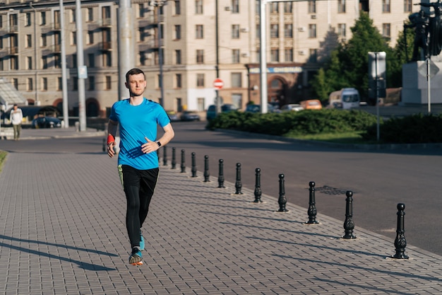 Attraktiver fit Mann, der in der Stadt läuft