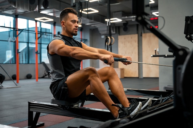 Attraktiver fitter Mann, der im Fitnessstudio trainiert