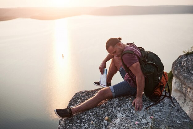 Attraktiver Mann, der den Blick auf die Berglandschaft über der Wasseroberfläche genießt.