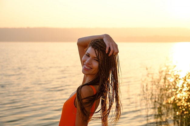 Attraktives Mädchen im Badeanzug am Strand bei Sonnenaufgang