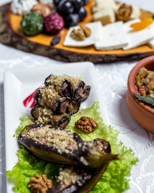 Auberginenrolle Walnüsse Zwiebel Knoblauch Frischkäse auf Salat Seitenansicht