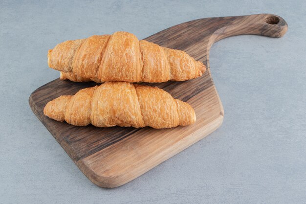 Auf dem blauen Hintergrund übereinander gestapeltes Croissant. Hochwertiges Foto