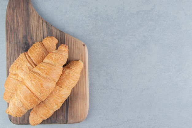 Auf dem blauen Hintergrund übereinander gestapeltes Croissant. Hochwertiges Foto