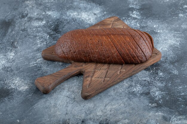 Auf grauem Hintergrund. Hausgemachtes Bio-Pumpernickel-Roggenbrot in Scheiben geschnitten. Hochwertiges Foto