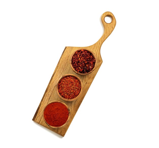 Auf küchenbrett drei schalen mit orientalischen gewürzen safran paprika kurkuma