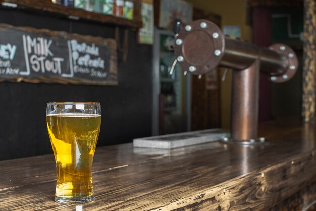 Auffrischungsglas der Seitenansicht mit Bier auf Tabelle