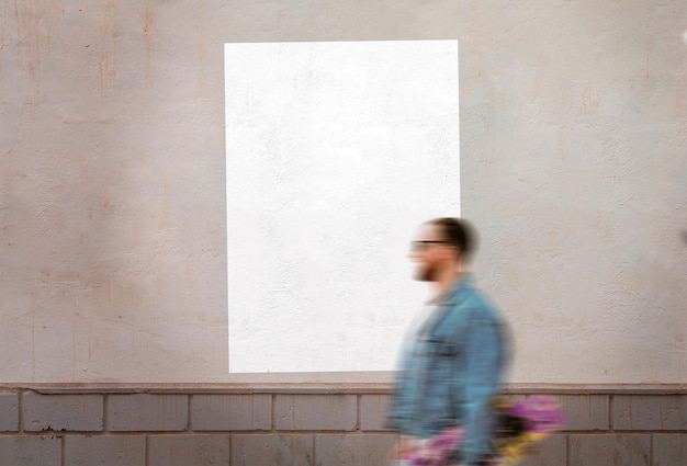 Aufgeklebtes weißes leeres Poster über Wand mit Fußgänger