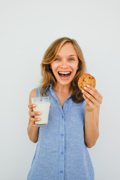 Aufgeregte Frau Holding Glas Milch und Plätzchen