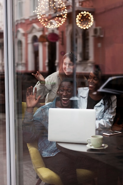 Kostenloses Foto aufgeregte gemischtrassige freunde durch fenster