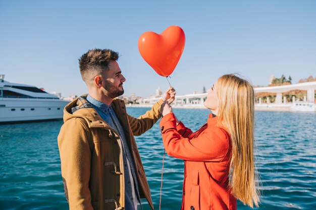 Kostenloses Foto aufgeregte junge leute mit ballon