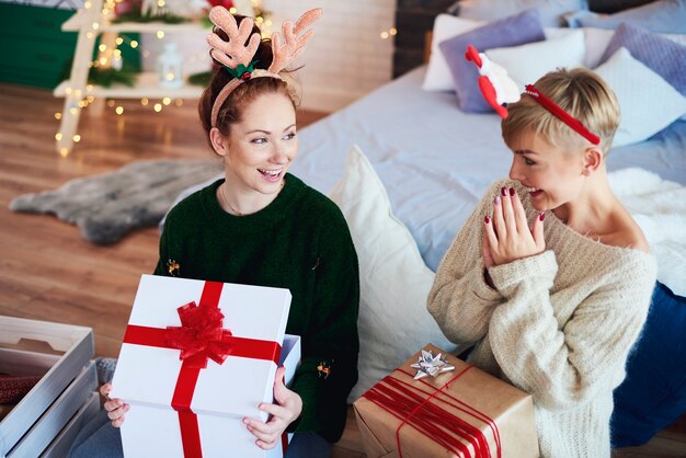 Aufgeregte Mädchen, die Weihnachtsgeschenk öffnen