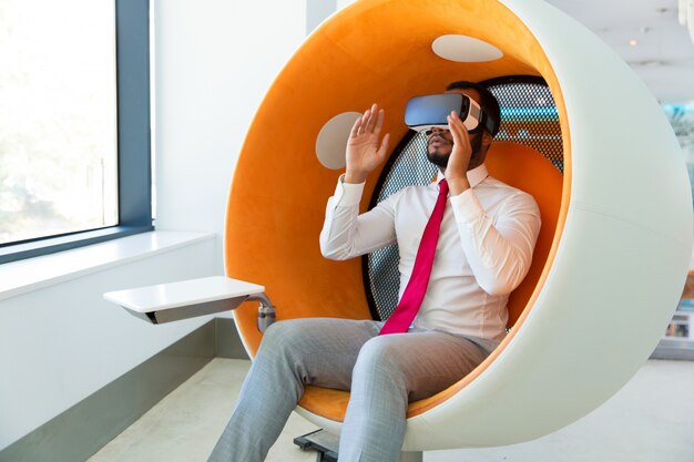 Aufgeregter ernster Fachmann, der VR-Gläser verwendet