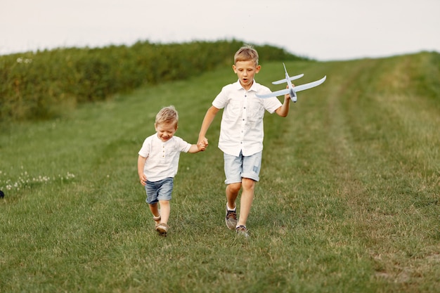 Aufgeregter kleiner Junge, der mit einem Spielzeugflugzeug läuft