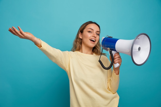 Aufgeregtes junges Mädchen, das durch Sprecher spricht, der Hand ausstreckt