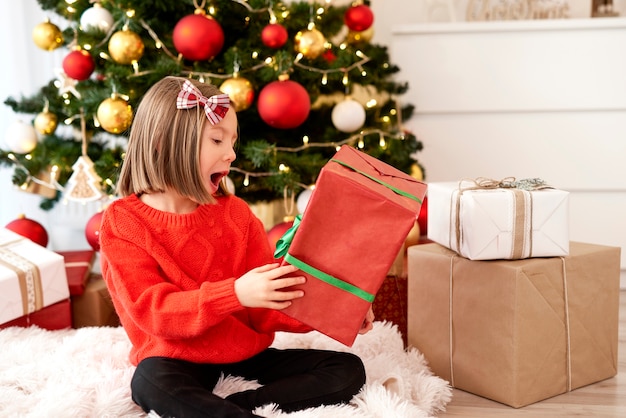 Aufgeregtes Mädchen mit Weihnachtsgeschenk