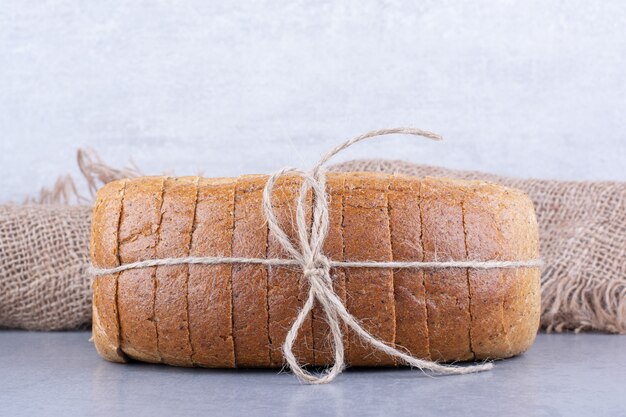 Aufgeschnittener Brotblock auf Marmoroberfläche gebunden