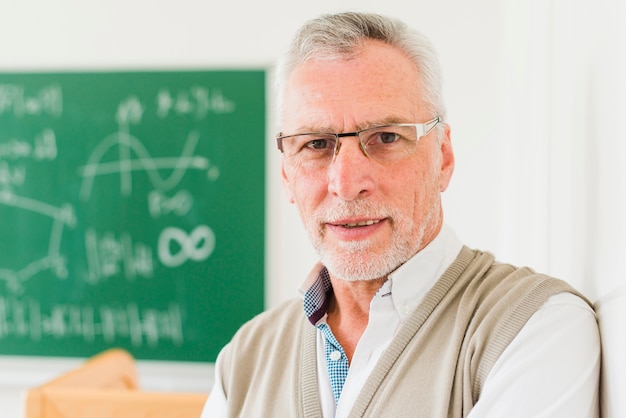 Kostenloses Foto aufmerksamer gealterter mathelehrer in den gläsern