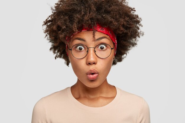 Aufnahme einer erschrockenen jungen Frau mit angehaltenem Atem, geöffneten Augen und verwundertem Blick