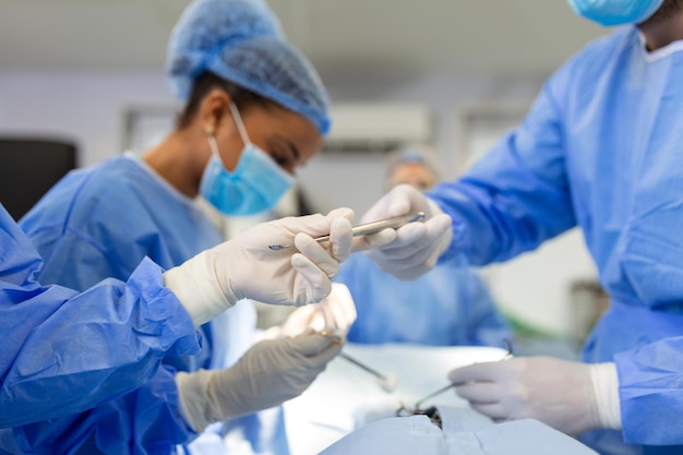 Aufnahme im OP-Saal Assistent übergibt Instrumente an Chirurgen während der Operation Chirurgen führen Operation durch Professionelle Ärzte führen Operationen durch