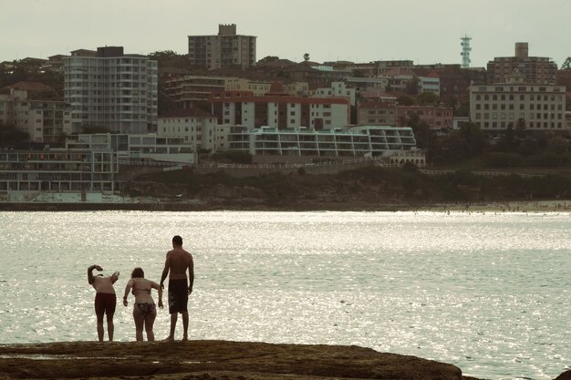 Aufnahme von Freunden auf Augenhöhe, die in Bondi Beach, Sydney, Australien, ins Meer springen