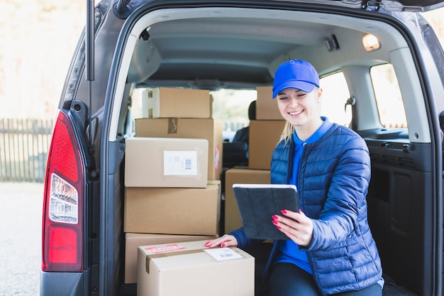 Aufpassende Tablette des Mädchens, die Post mit dem Auto liefert