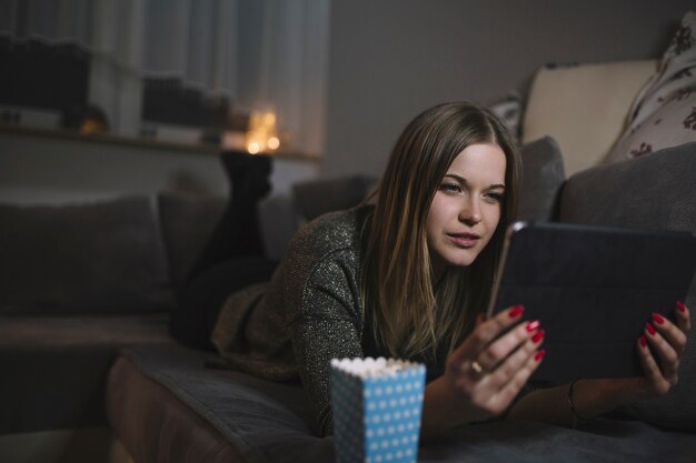 Aufpassender Film der Frau auf Couch