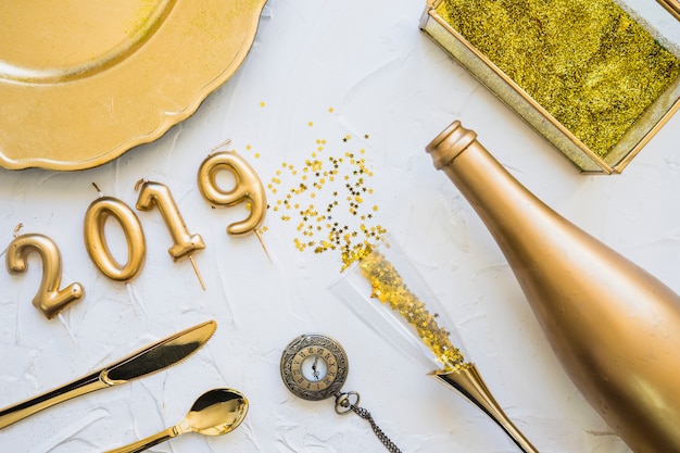 Kostenloses Foto aufschrift 2019 von den kerzen mit flasche auf tabelle