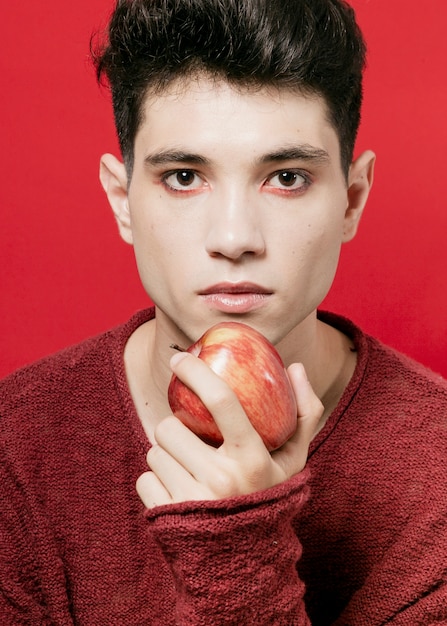 Aufwerfender Mann beim Apfel in der Hand halten