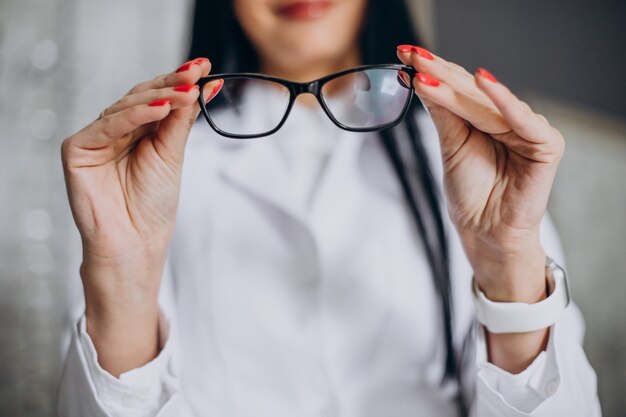 Augenärztin, die Brille im Optikergeschäft demonstriert