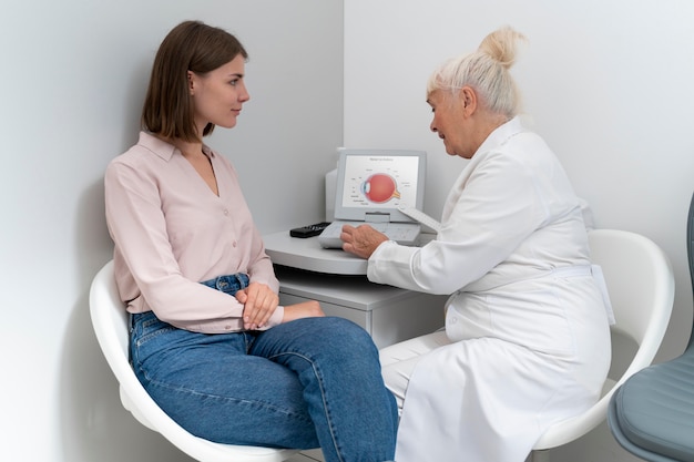 Kostenloses Foto augenarzt überprüft einen patienten in ihrer klinik