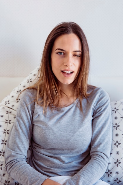 Kostenloses Foto augenzwinkernde frau auf dem bett