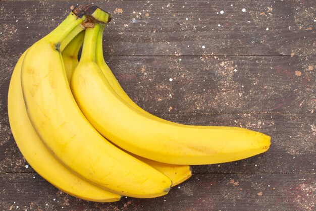 Aus der Nähe sehen Sie köstliche Bananen auf braunem exotischem Essen mit Fruchtbeeren