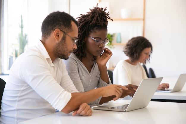 Ausbilder, der die firmenspezifische Software für Praktikanten erklärt