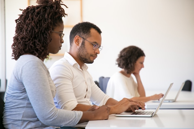 Ausbilder und Auszubildender, die zusammen Computer verwenden